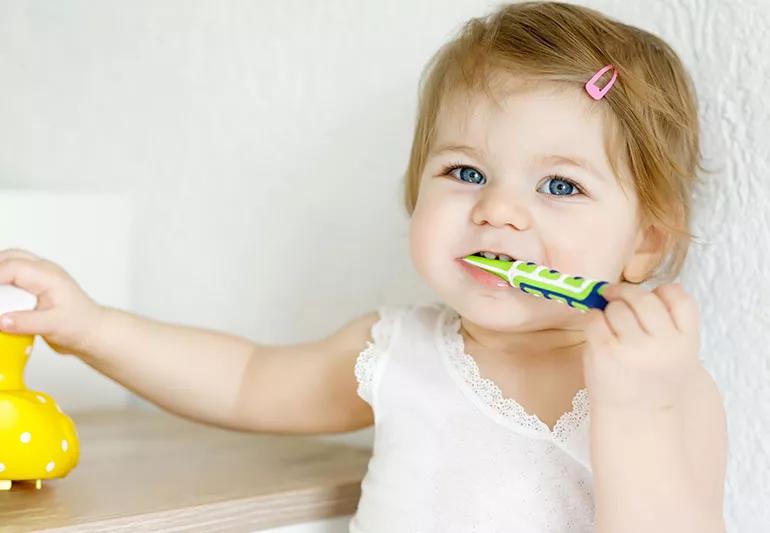 baby girl brushing first teeth
