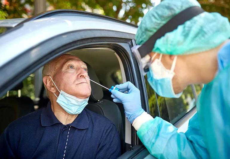 man getting a covid test from a healthcare worker