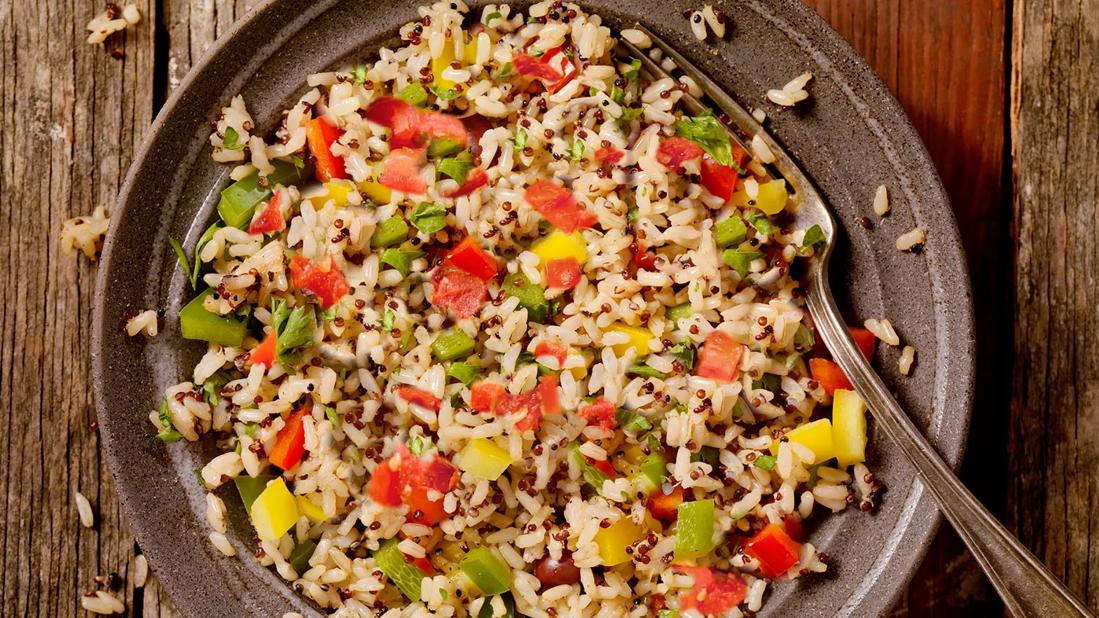 Rugged plate of mexican rice pilaf with fork on wooden table