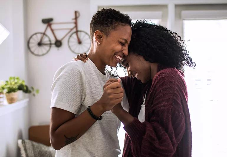 Couple dancing and laughing at a private space.