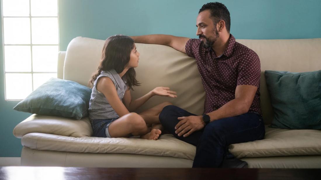 Child talking with caregiver on couch