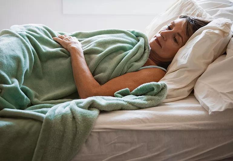 Person laying in bed looking concerned