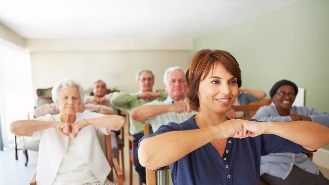 Seniors exercising with chairs