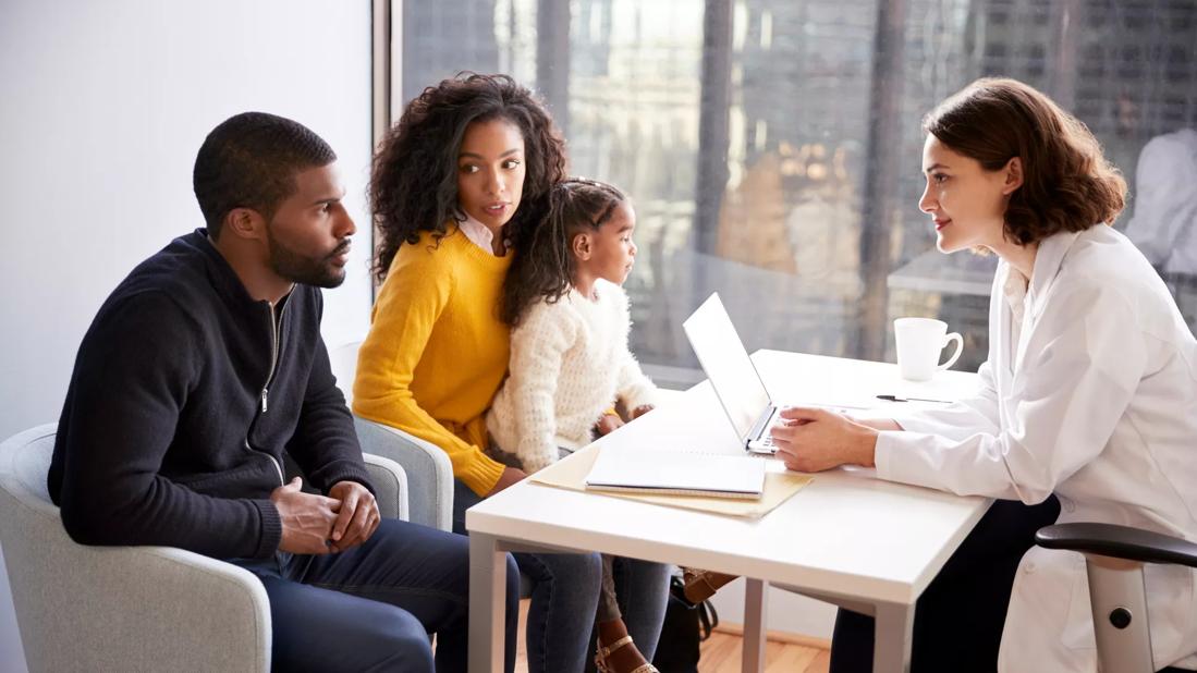 Mother, father and child meeting with doctor in medical office