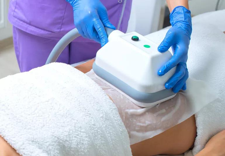 Technician performing body sculpting on a patient