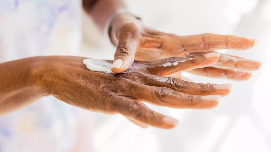 Moisturizer being applied to older hands