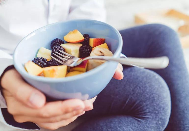 woman eating fruit salad