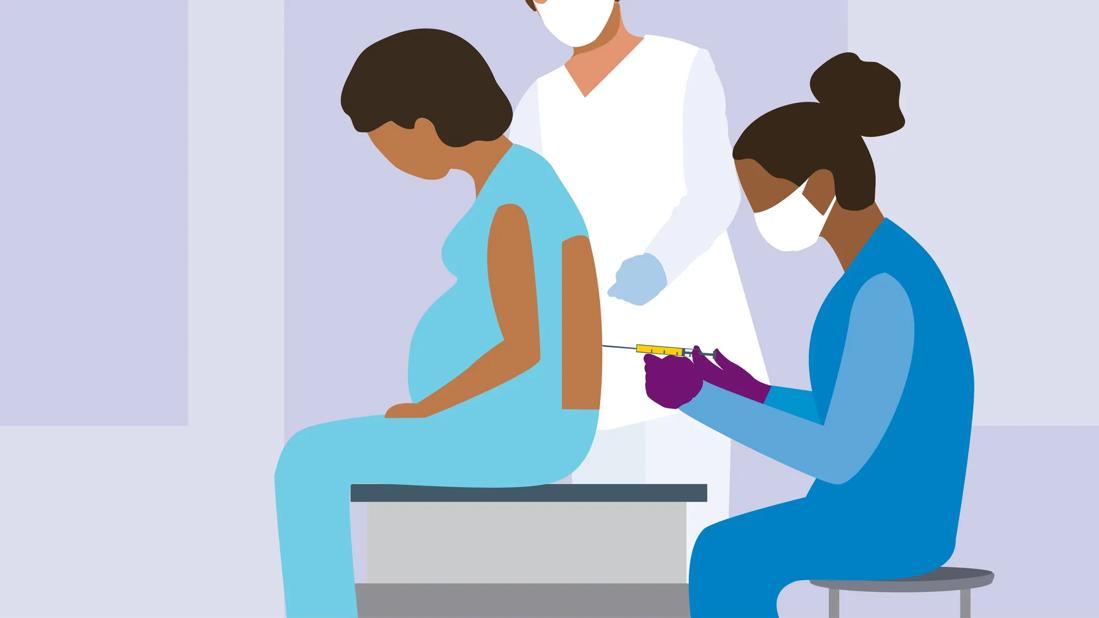 Pregnant female sitting, receiving an epidural from a healthcare provider, with other provider nearby