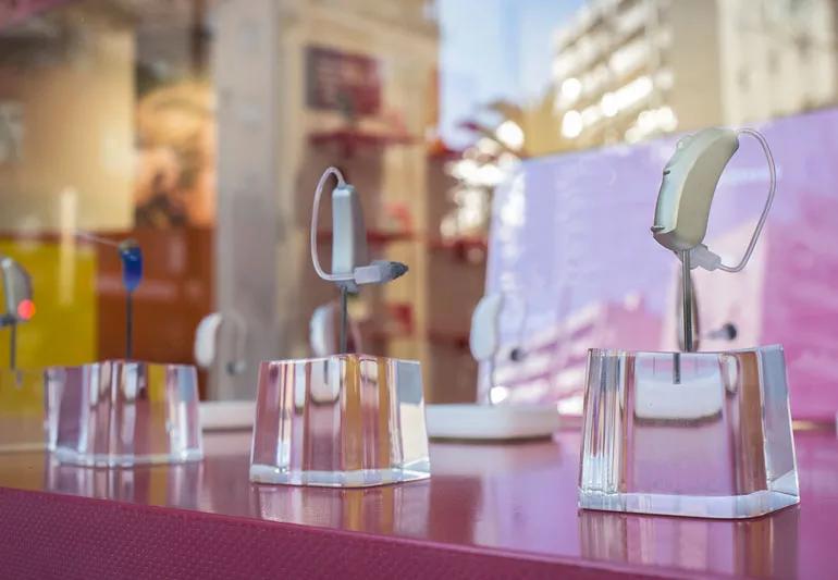 Hearing aids displayed for sale on a counter at a store.