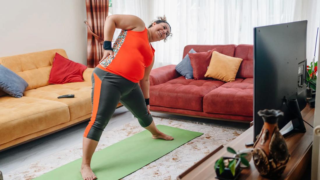 Pregnant woman exercising in living room