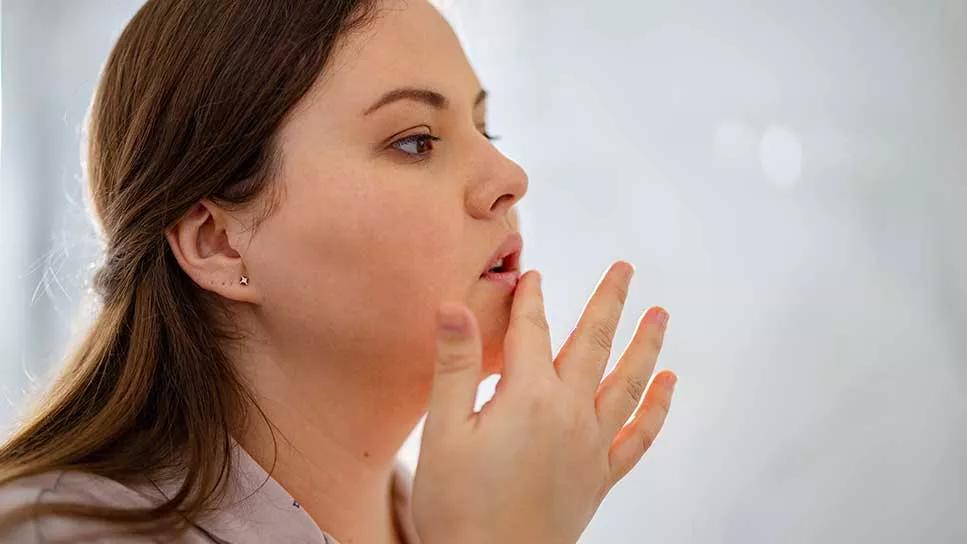 female applying lip balm to lips
