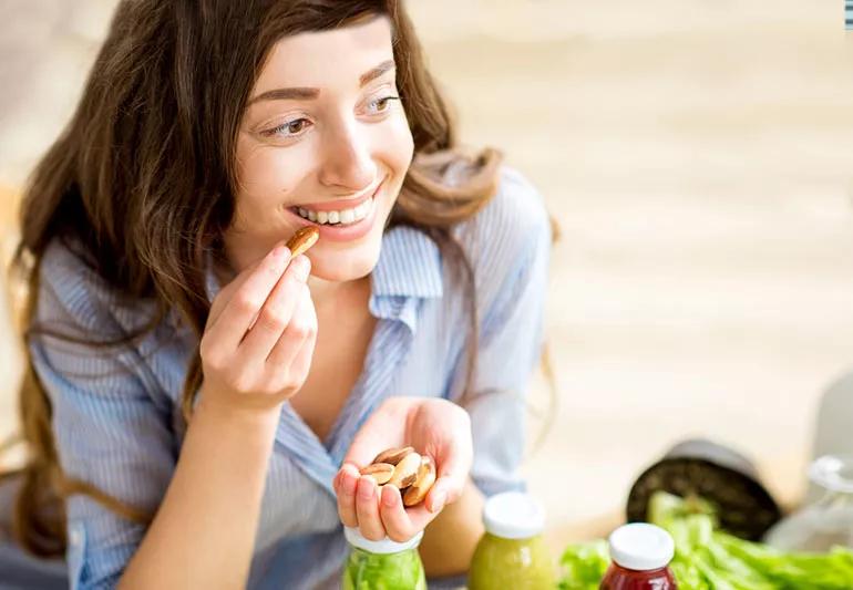 Woman eating handful of nuts