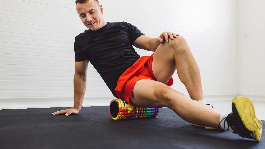 Person positioned on foam roller, stretching muscles