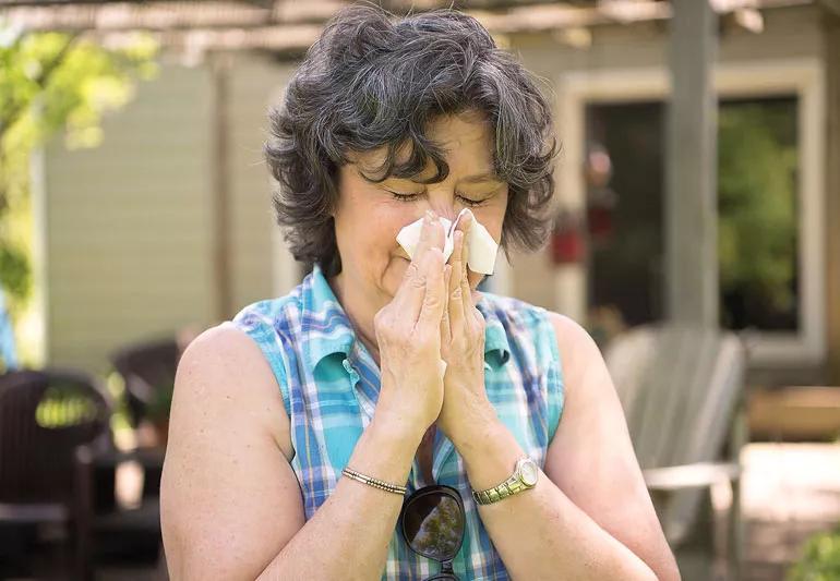 woman sneezing due to allergies