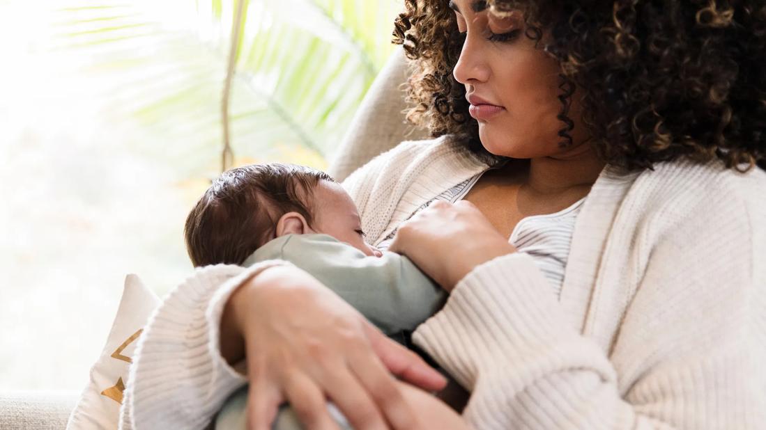 Mother gazing down at baby while breastfeeding