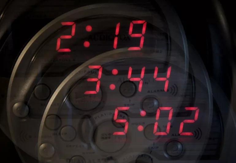 Multiple alarm clocks showing how people with insomnia struggle to fall asleep.