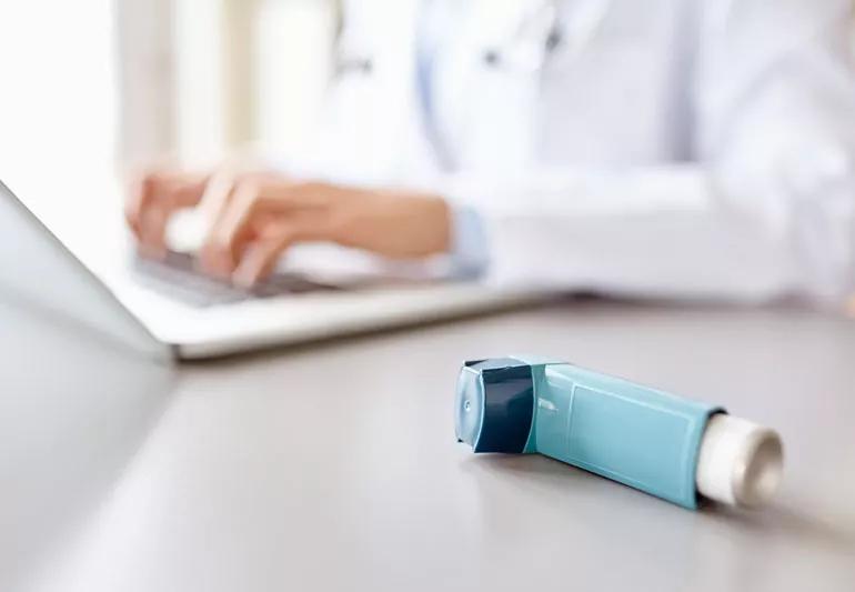 Inhaler in foreground on doctor's desk