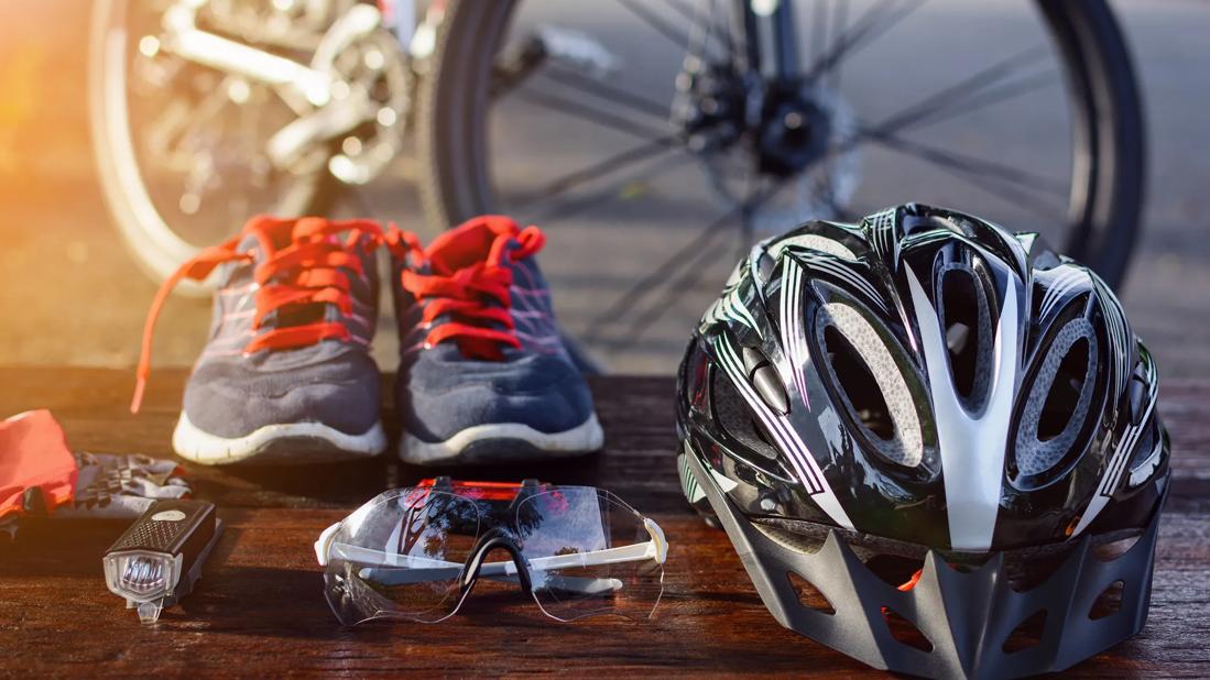 Assorted cycling riding gear, including a helmet, shoes, light and eye protection