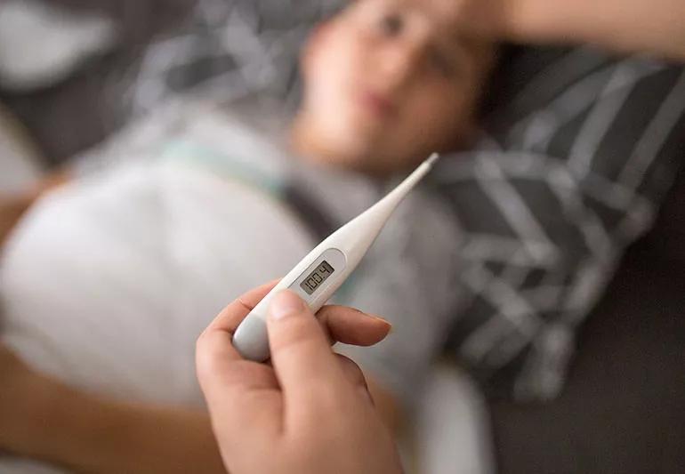 Parent taking a child's temperature.