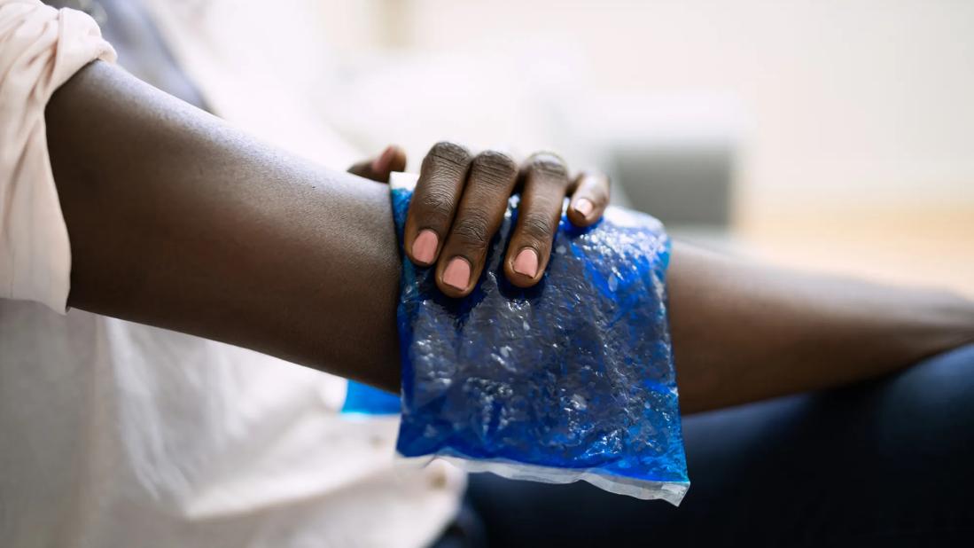 A person holds an ice pack on their arm