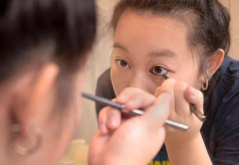 woman applying eyeliner