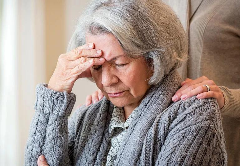 Older woman depressed and forgetful comforted by daughter