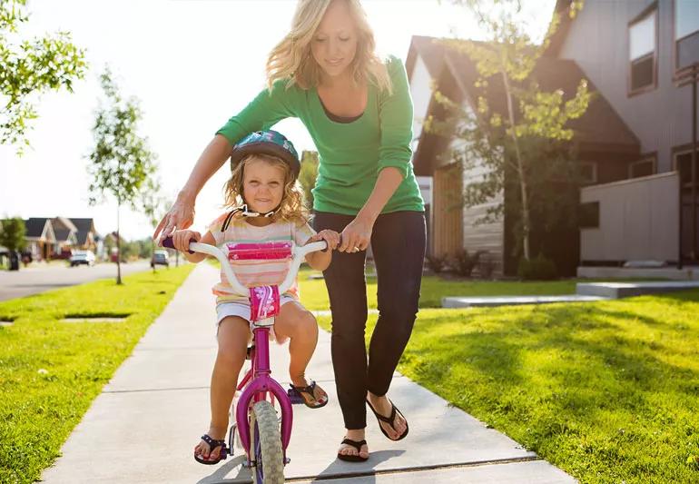 Mom with daughter trying to bike without training wheels
