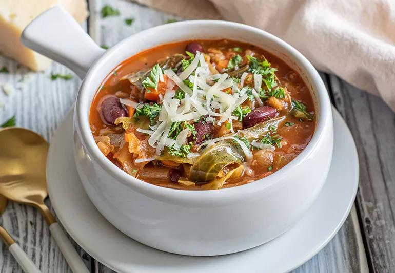 A small bowl of farro minestrone with a light dusting of parmesan cheese