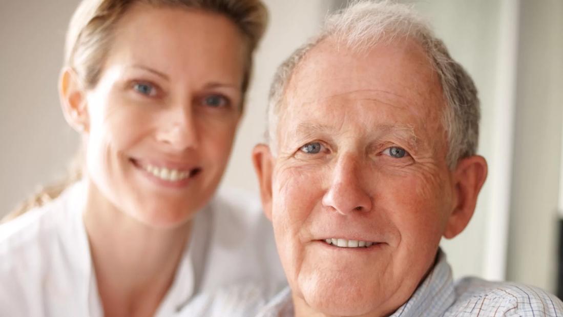 Elderly man on the wheelchair with a nurse