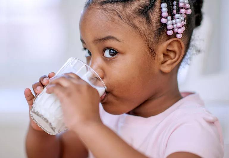 young girl drinks milk