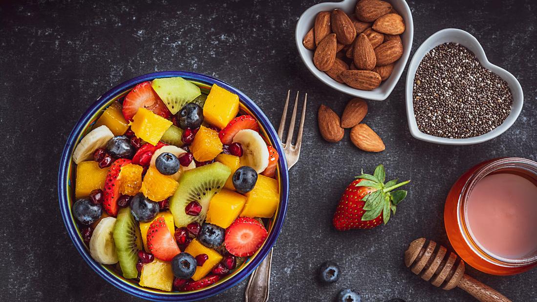 Bowl of assorted fruit and bowls of nuts and seeds