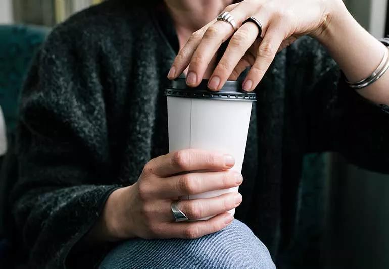 person holding to go cup of coffee