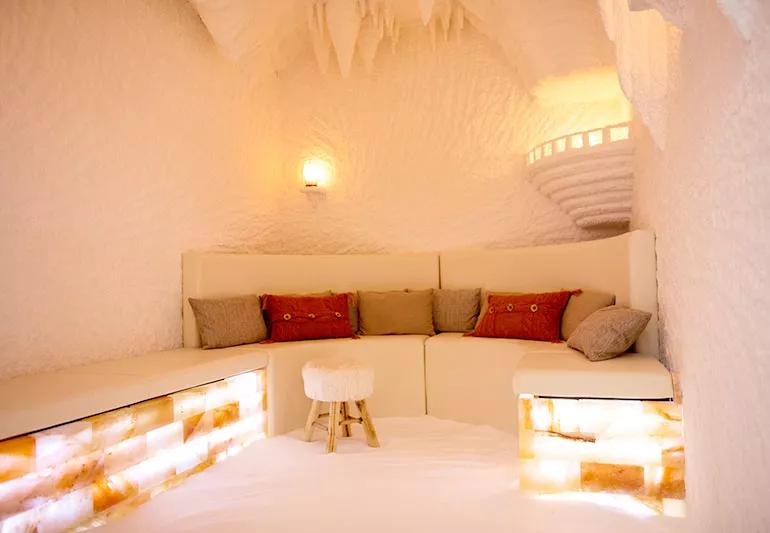 A couch with several pillows inside of a large Himalayan salt cave.