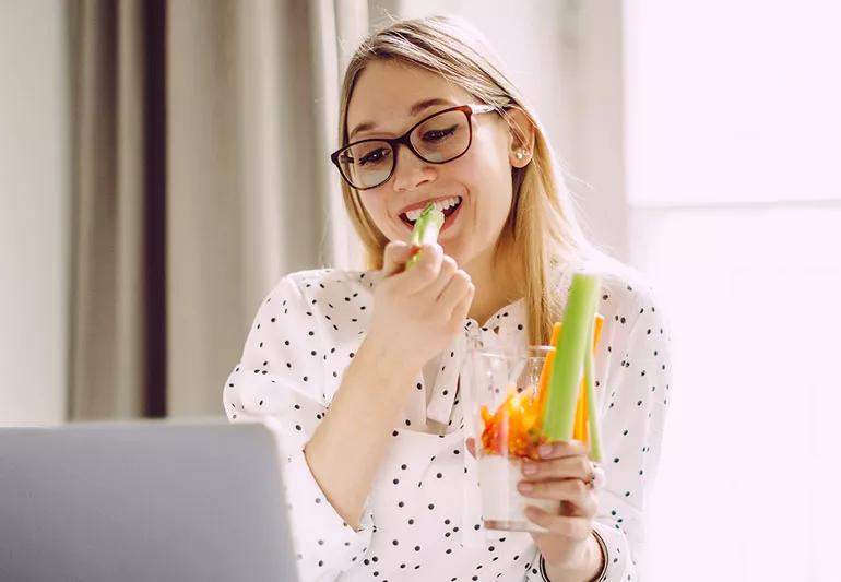 woman snacking on veggetables and yogurt dip