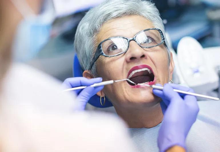 Elderly woman getting examined at dentist's office
