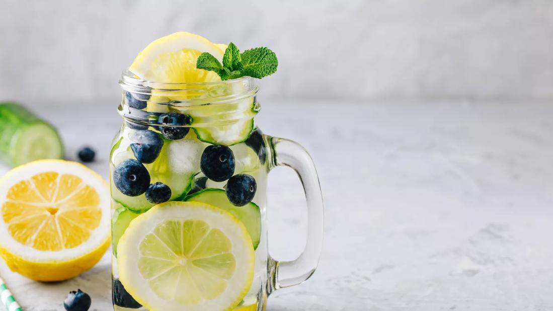 Water in mason jar mug with cucumber, blueberries and lemon