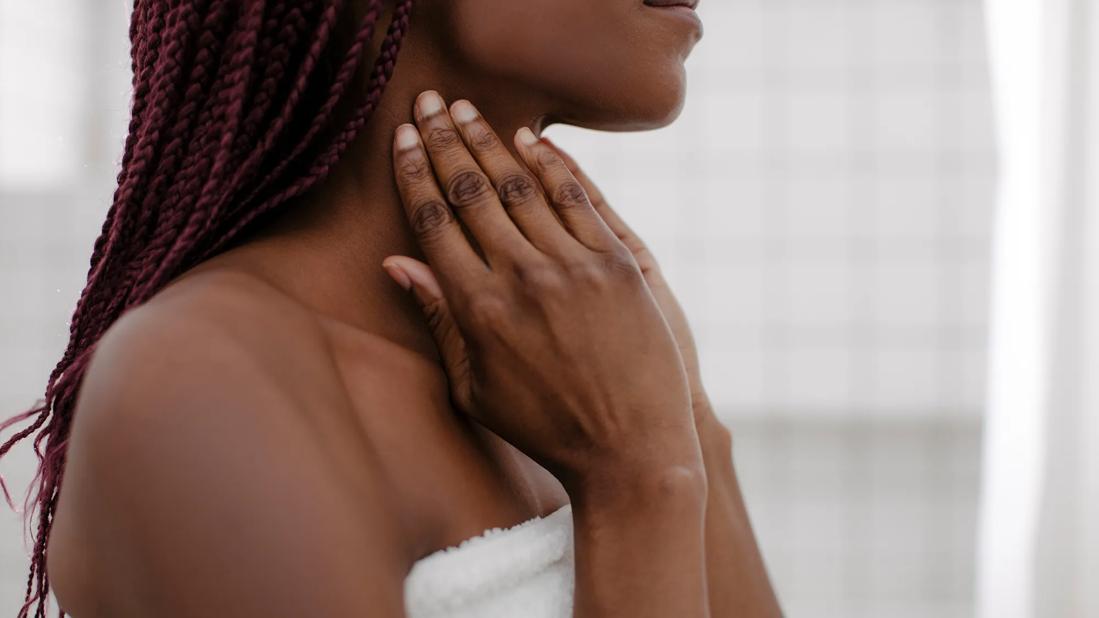 Woman in a towel massaging neck