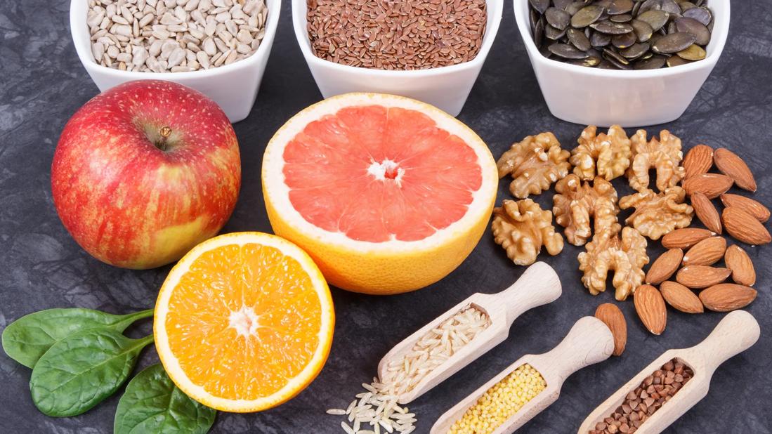 Assorted fruits, nuts and seeds in bowls and on table