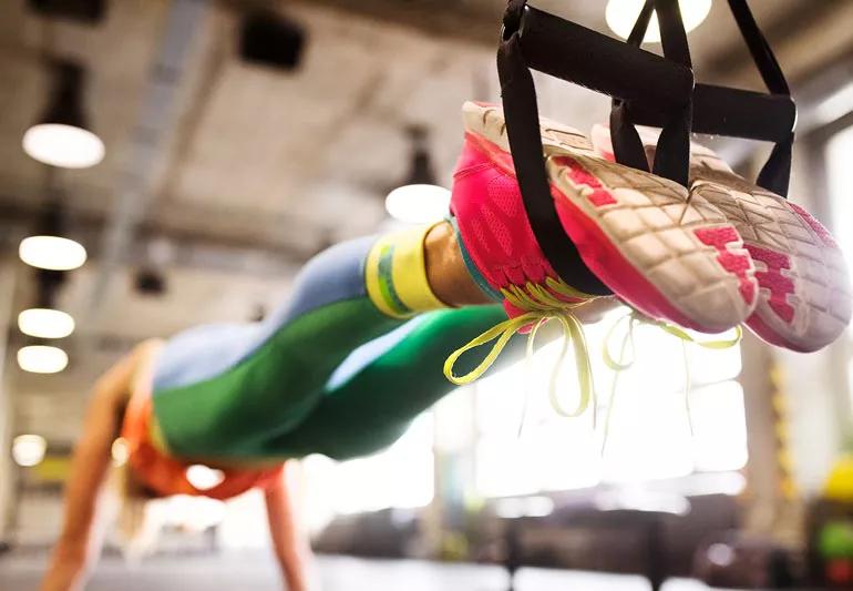 person using suspension training during push-up