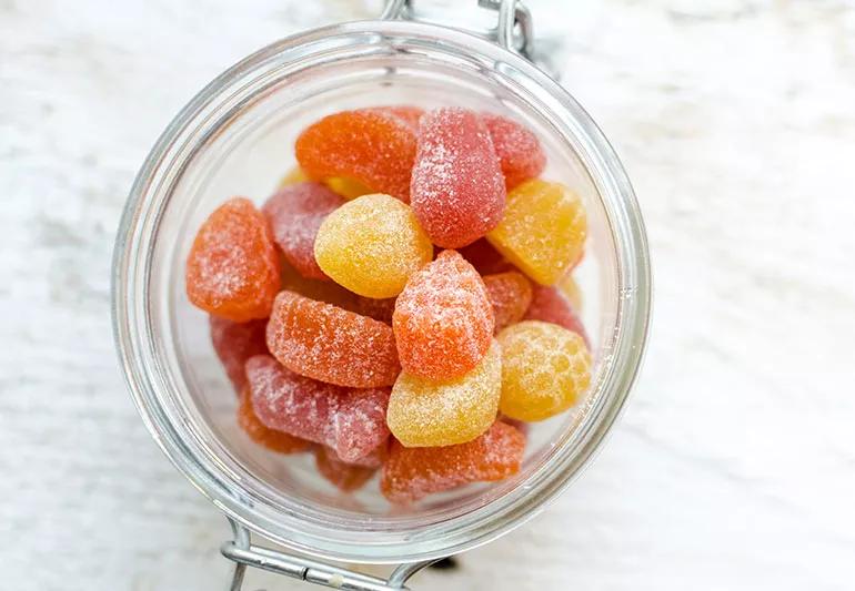A bowl of red, orange and yellow gummy vitamins