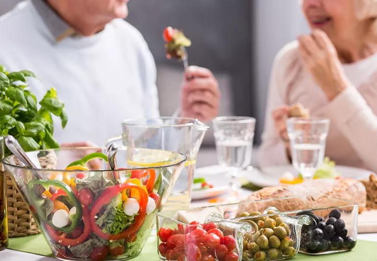 Older couple eating healthy vegetables for meal