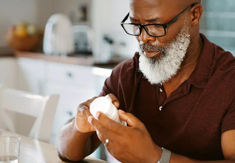 Person looking at a vitamin container.