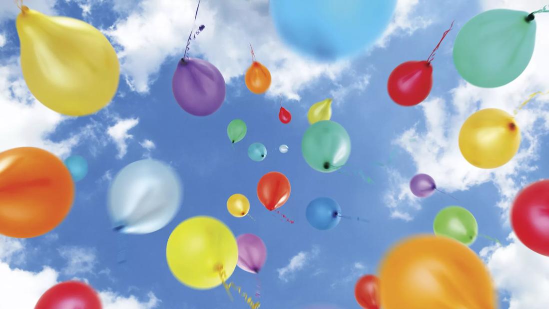 Multi-Coloured Balloons Move Upwards Into a Summer Sky