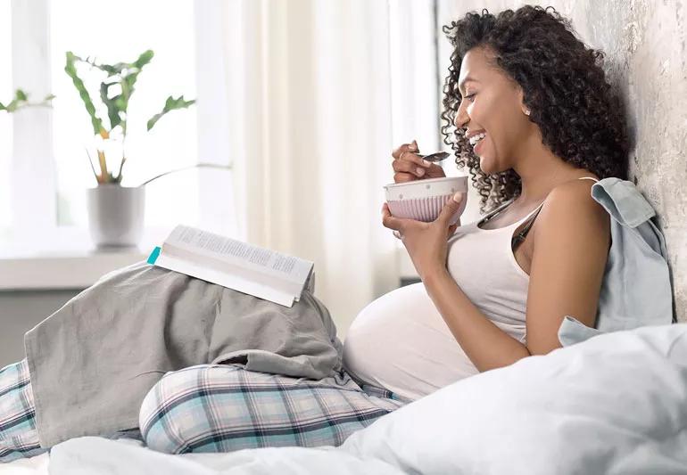 pregnant woman eating healthy in bed