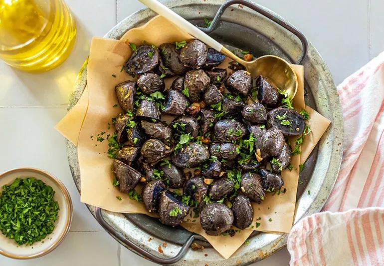 A bowl of roasted Peruvian purple potatoes with rosemary