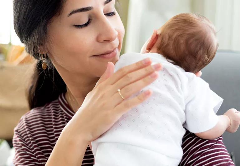 A person burping her baby.