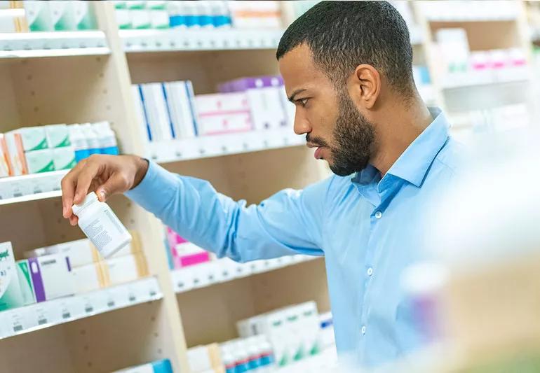 Man in drugstore choosing supplements