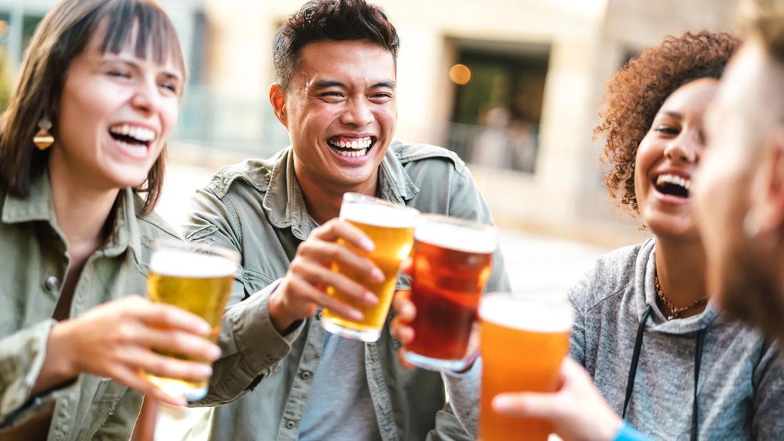 Group of happy, smiling friends raising a toast with glasses of beer