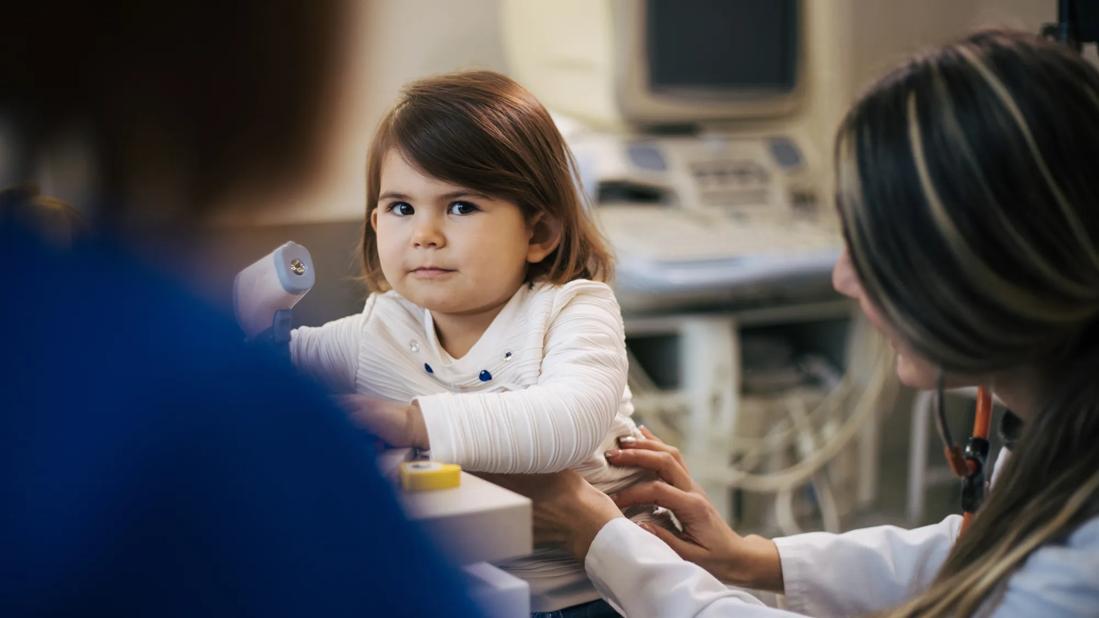 Female child being examined by healthcare provider in medical office