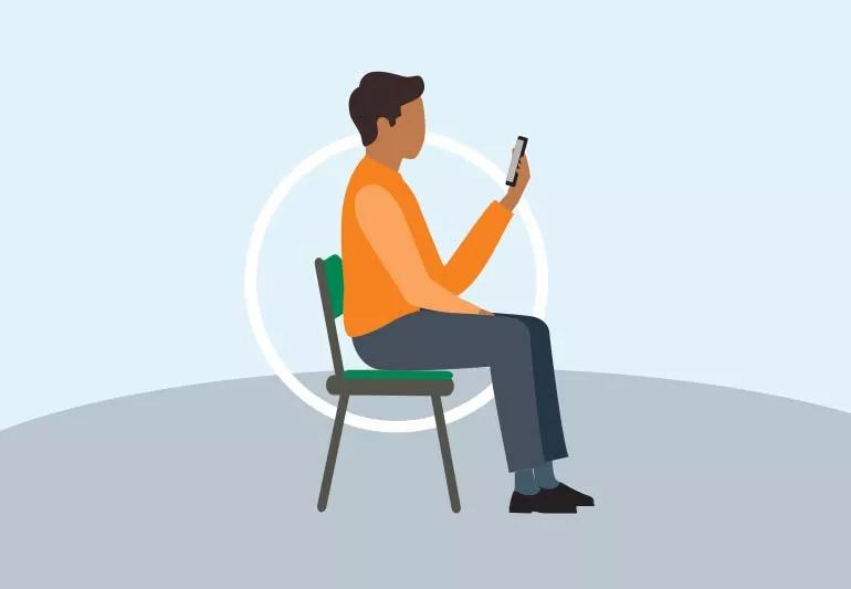 Person sitting up straight in chair while checking smartphone.